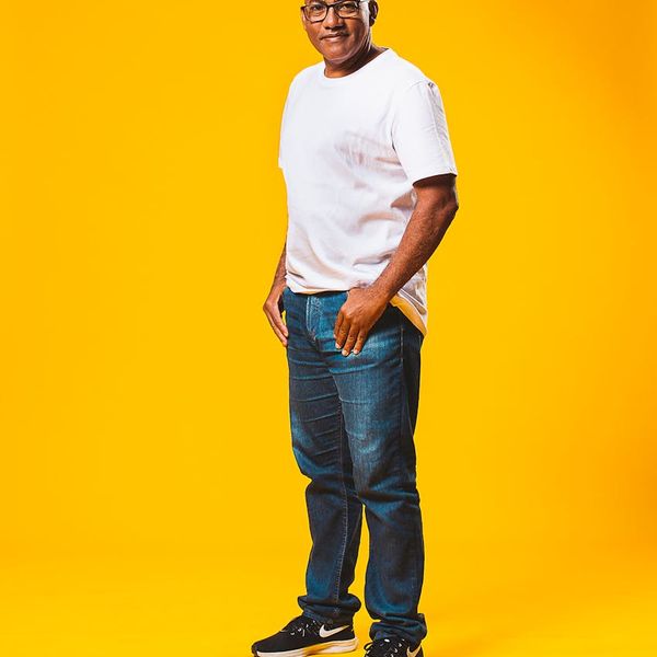 Person doing an energizing yoga pose against a bright yellow background.