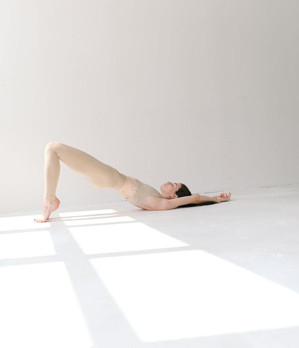 Woman in a calming yoga pose in a studio with soft light.